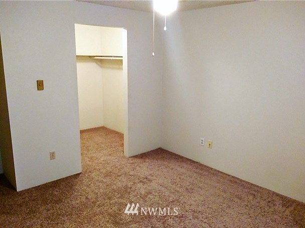 3914 Mason Loop Road, Unit 14 Tacoma, WA 98409 - Photo 22 of 25 an empty room with closet and mirror