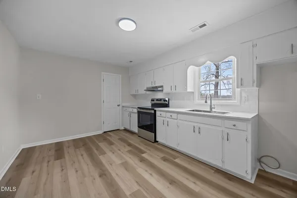 a kitchen with granite countertop a sink cabinets stainless steel appliances and a counter space