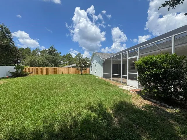 a view of an house with backyard and garden