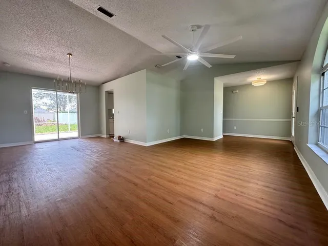 an empty room with wooden floor and window