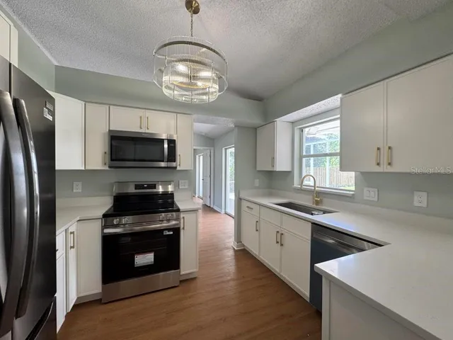 a kitchen with stainless steel appliances a stove microwave and a refrigerator