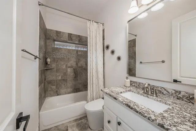 a bathroom with a granite countertop sink toilet and shower