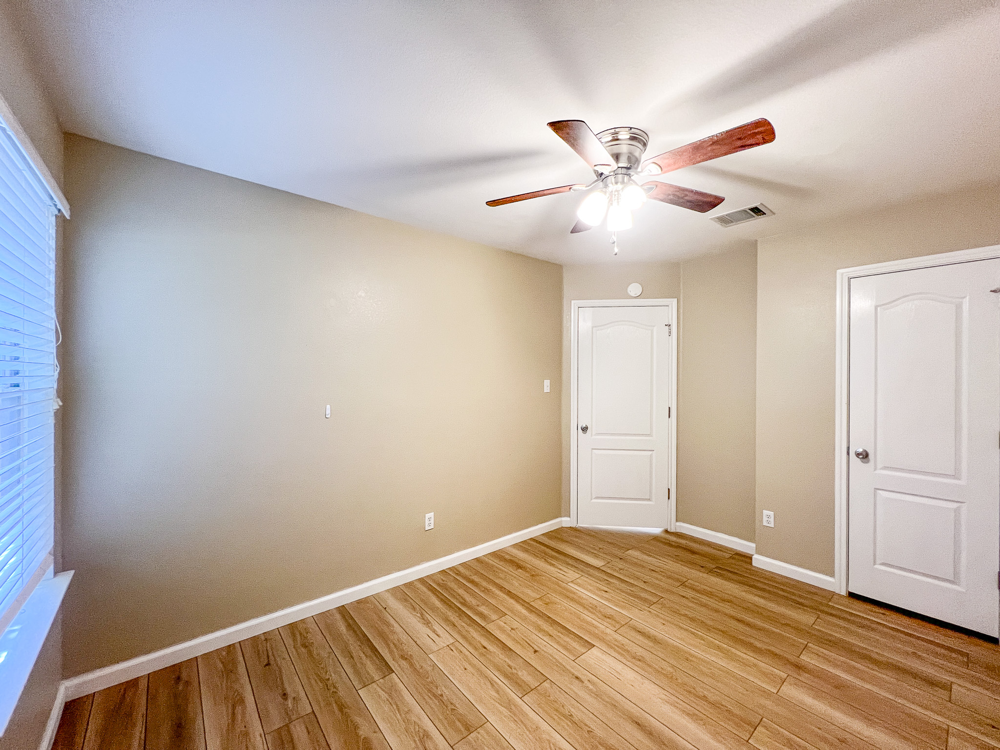 298 Jack Rabbit Lane Buda, TX 78610 - Photo 11 of 24 Wood-look flooring and a functional ceiling fan define this comfortable bedroom space.