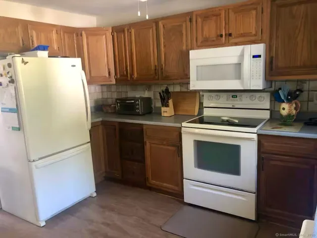a view of a roof deck with table and chairs with wooden floor and fence