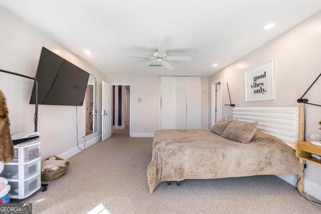 a bedroom with a bed closet and a flat tv screen