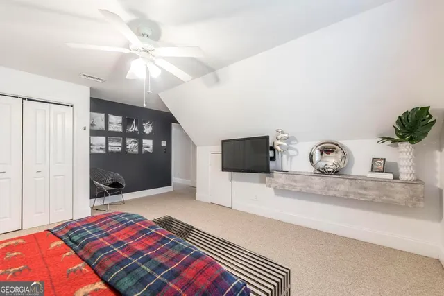 a bedroom with a bed and a flat tv screen on dresser