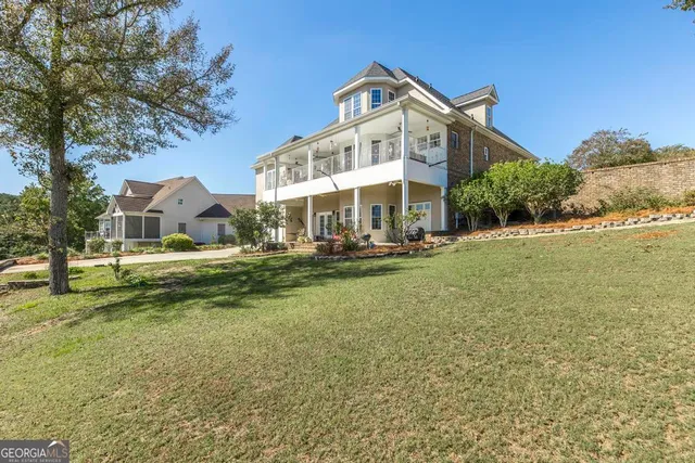 a view of a house with a big yard and large trees