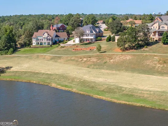 an aerial view of residential houses with outdoor space and ocean view