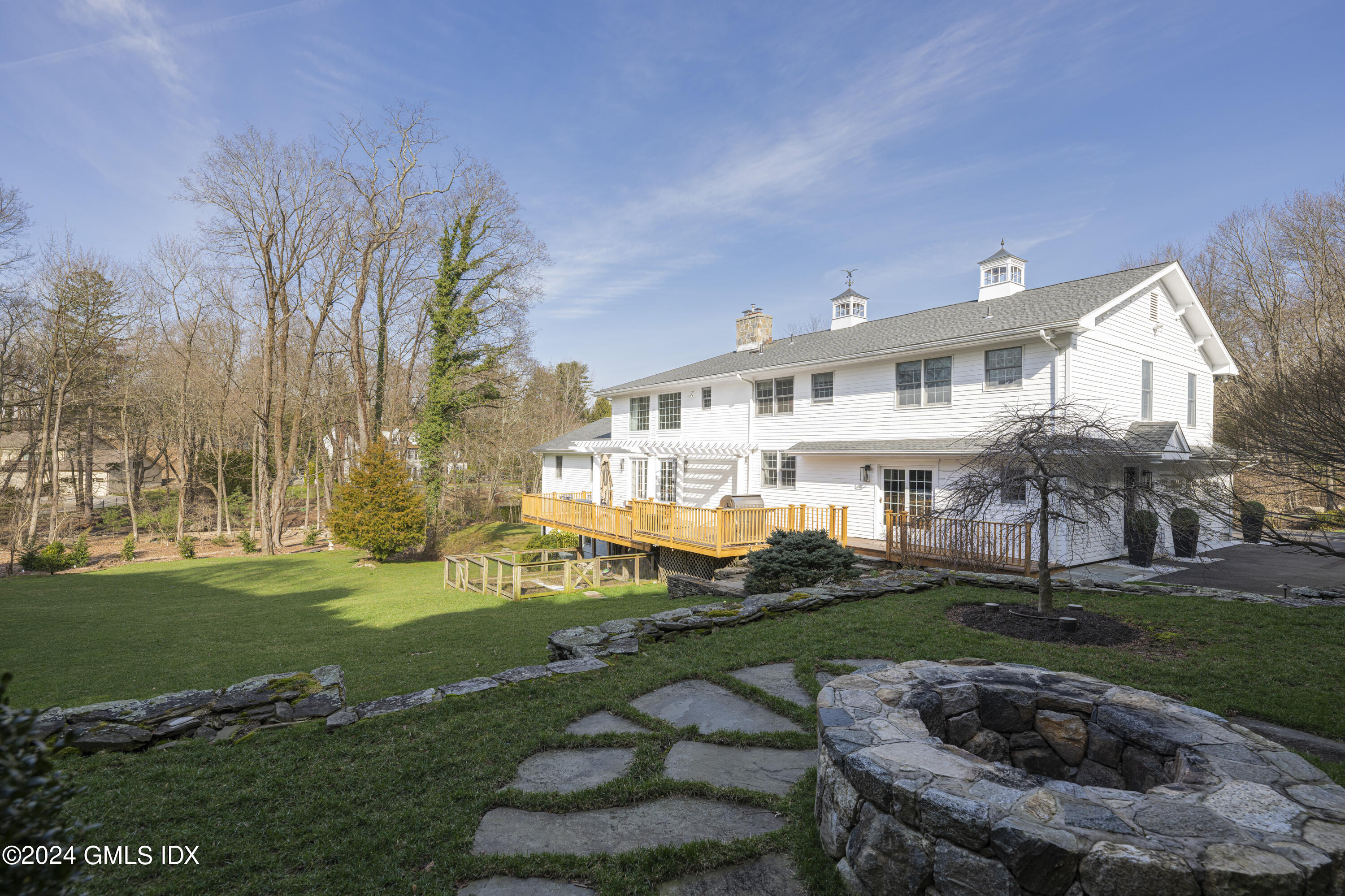 17 Rustic View Road Greenwich, CT 06830 - Photo 2 of 26 a view of a white house in a big yard with potted plants and large trees