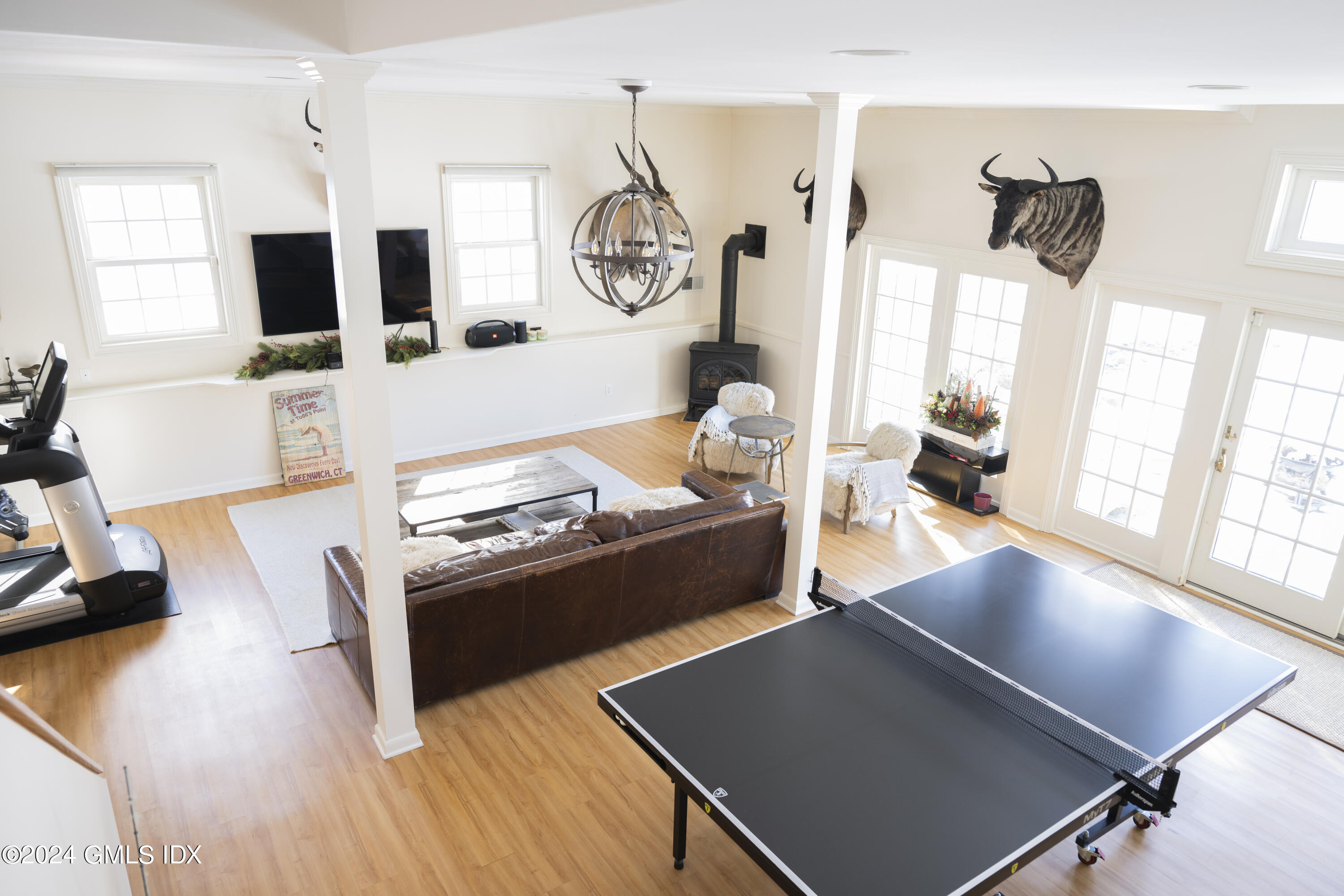 17 Rustic View Road Greenwich, CT 06830 - Photo 21 of 26 a living room with couches bookshelf and a stove with wooden floor