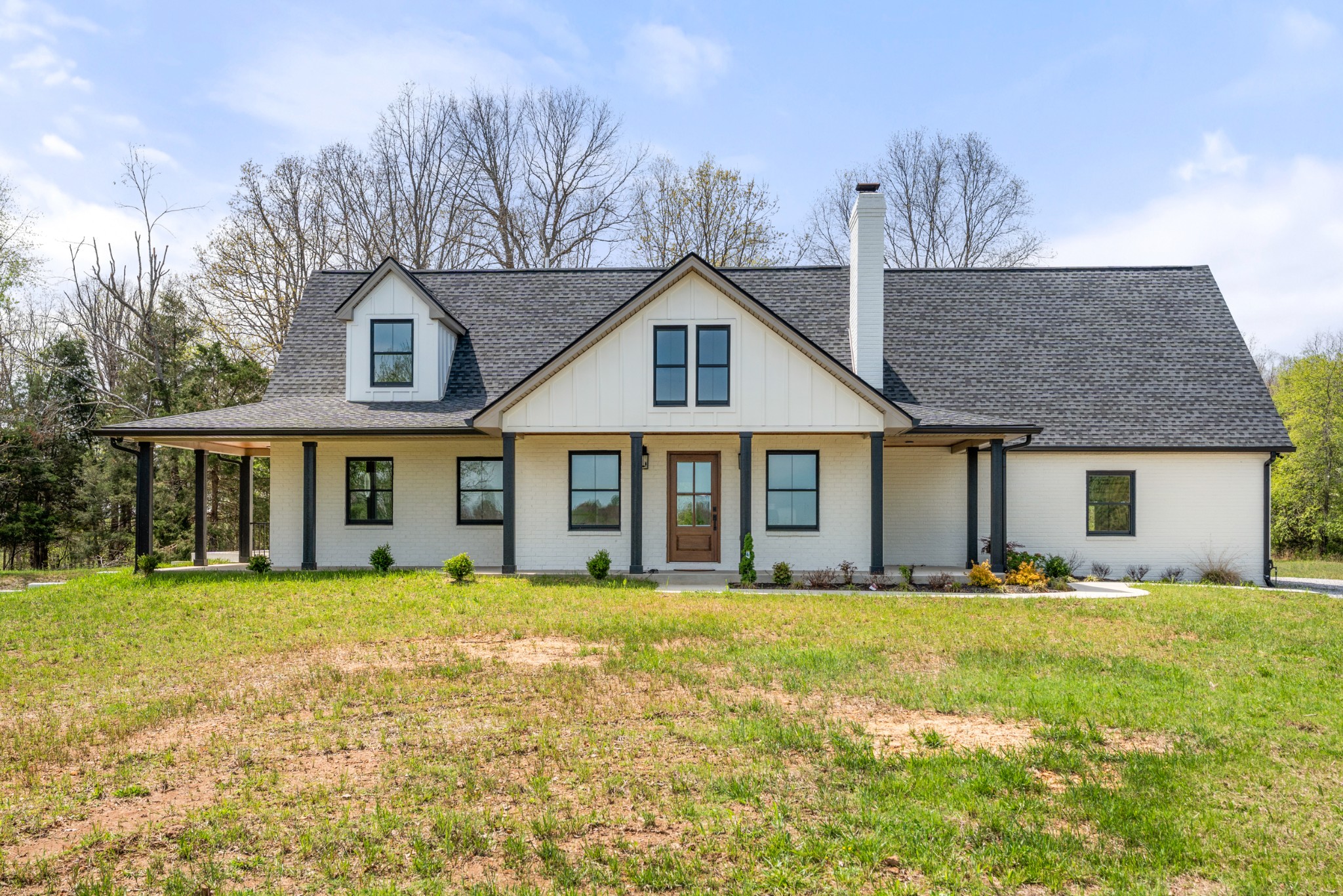 a front view of a house with a yard and trees