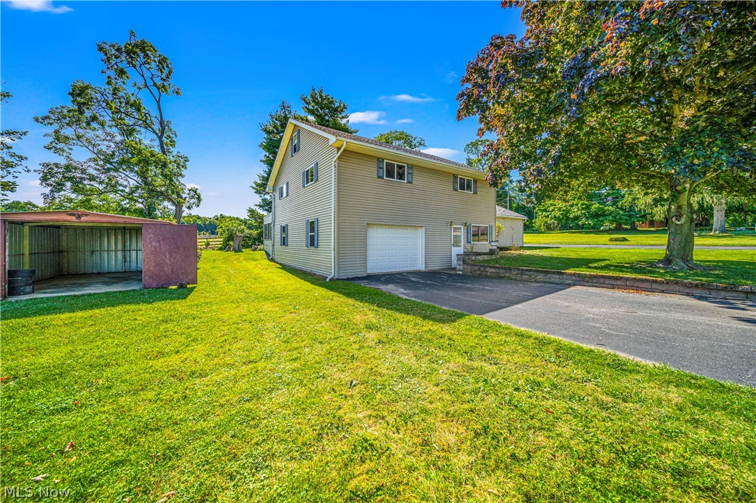 4573 Elberta Road Perry, OH 44081 - Photo 2 of 32 Side View of property exterior with a garage and out building