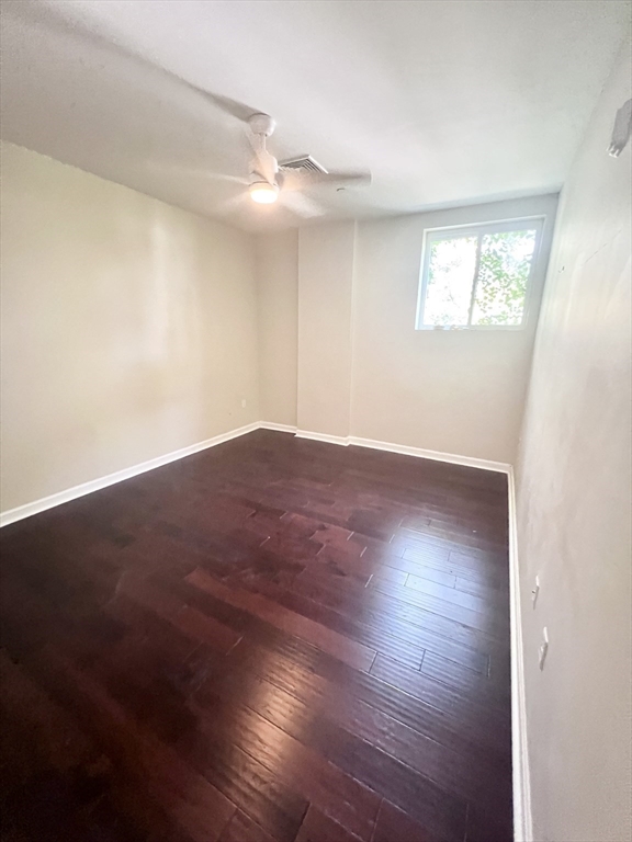 202 Broadway, Unit 33 Lawrence, MA 01840 - Photo 11 of 13 an empty room with wooden floor and windows