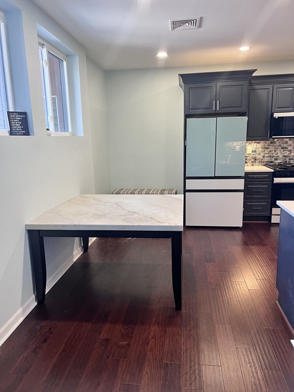 202 Broadway, Unit 33 Lawrence, MA 01840 - Photo 6 of 13 a hallway with a wooden floor and cabinets