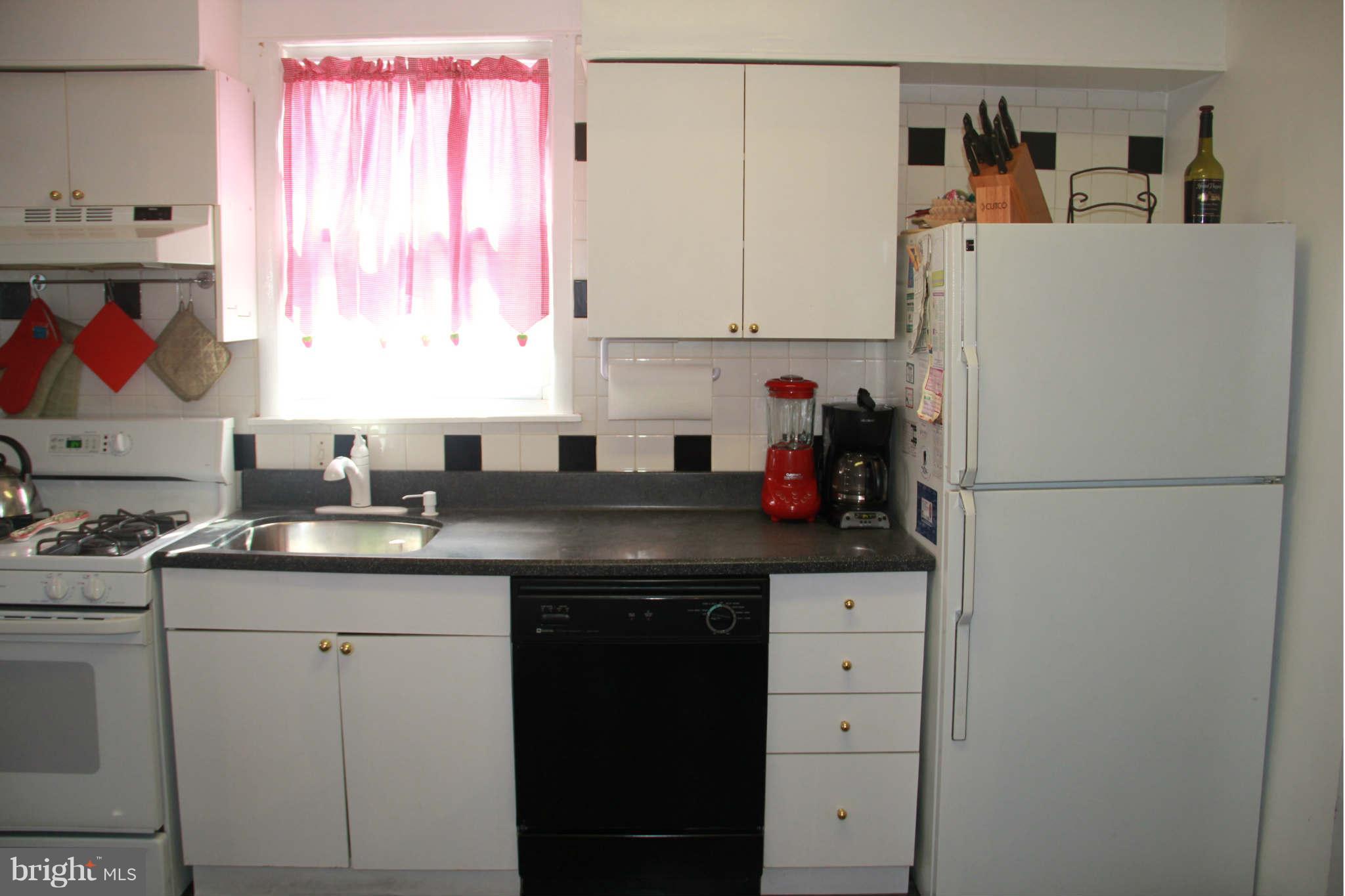 6313 Banbury Road Baltimore, MD 21239 - Photo 13 of 21 a kitchen with a sink a refrigerator and cabinets
