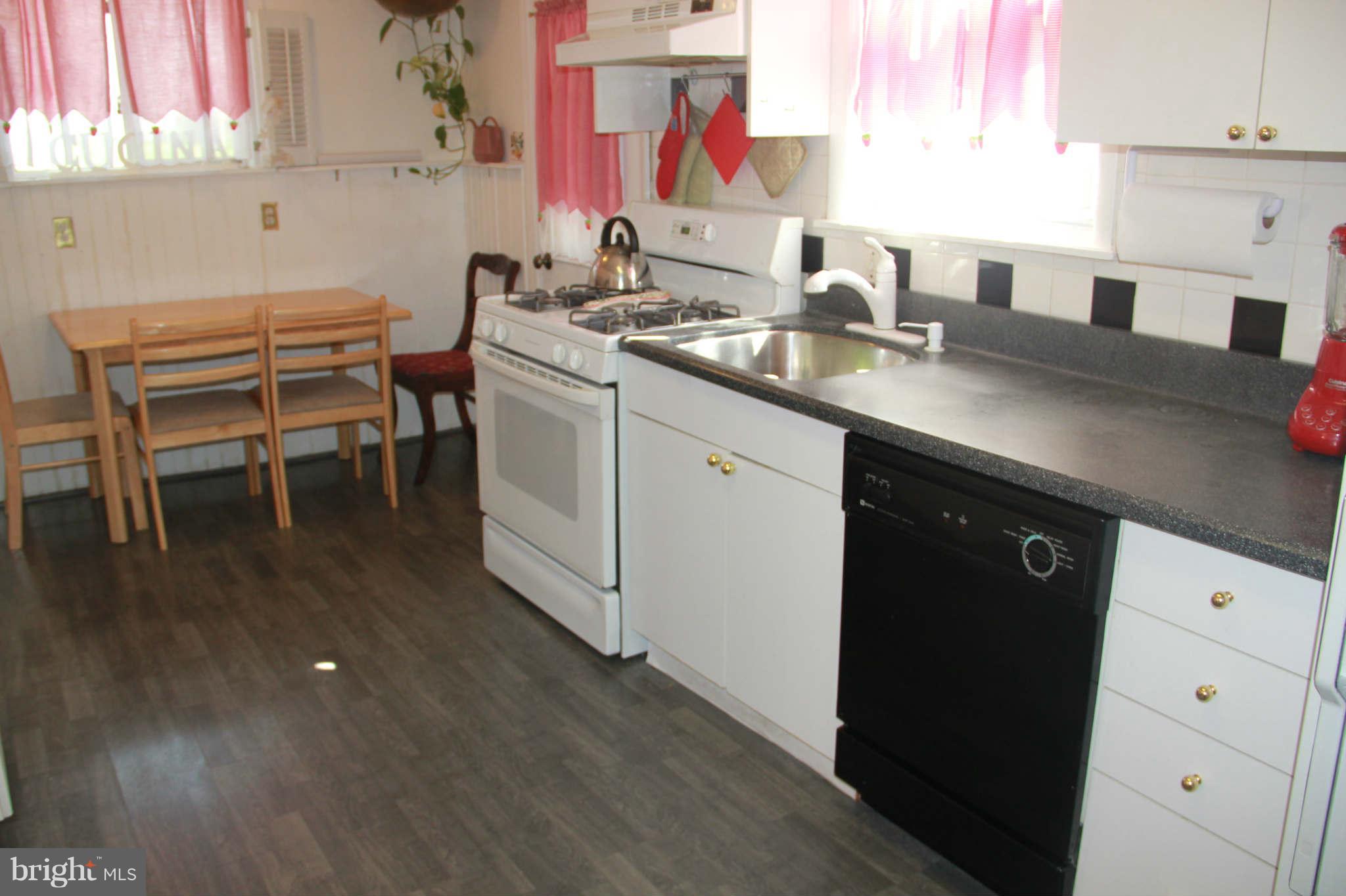 6313 Banbury Road Baltimore, MD 21239 - Photo 15 of 21 a kitchen with a sink cabinets and wooden floor