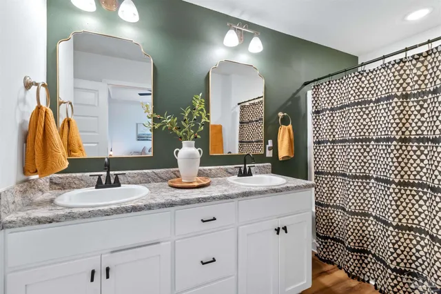 a bathroom with a granite countertop sink a toilet and shower