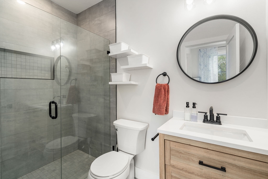 152 Marion Street, Unit 6L Boston, MA 02128 - Photo 14 of 22 a bathroom with a sink a toilet and a mirror