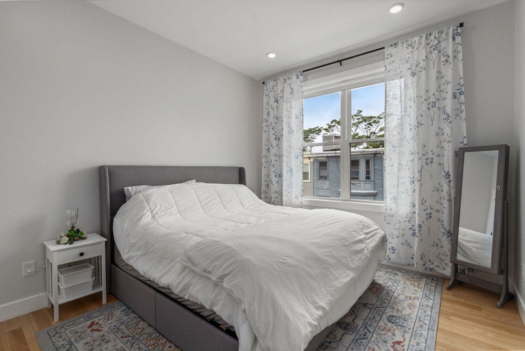 152 Marion Street, Unit 6L Boston, MA 02128 - Photo 15 of 22 a bedroom with a bed and a view of bathroom