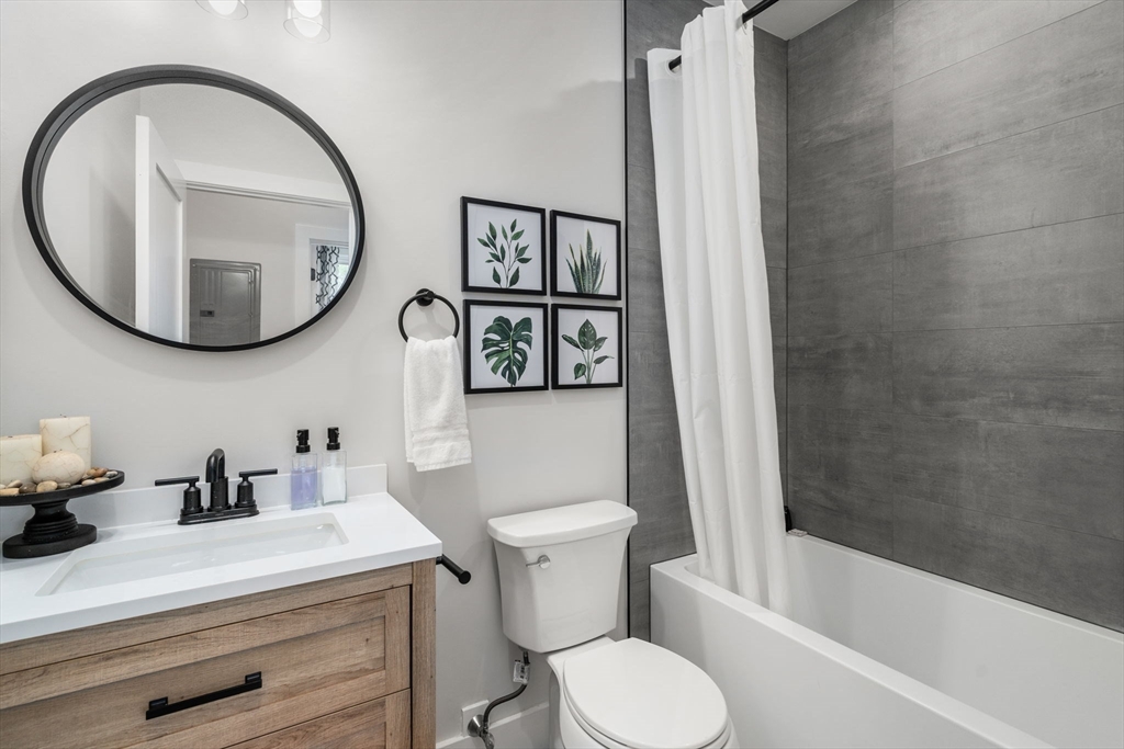 152 Marion Street, Unit 6L Boston, MA 02128 - Photo 16 of 22 a bathroom with a sink a toilet and a mirror