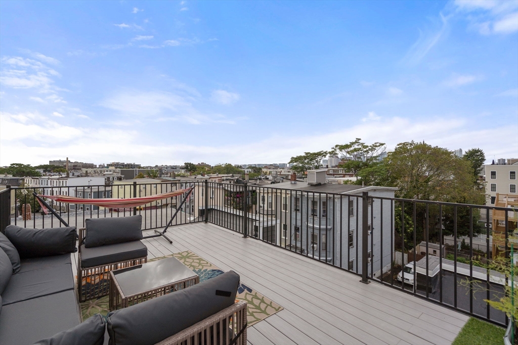 152 Marion Street, Unit 6L Boston, MA 02128 - Photo 2 of 22 a balcony with wooden floor table and chairs