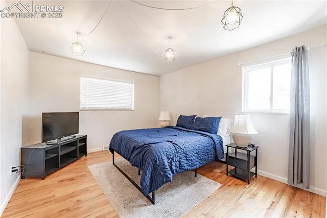 a spacious bedroom with a bed and a flat screen tv