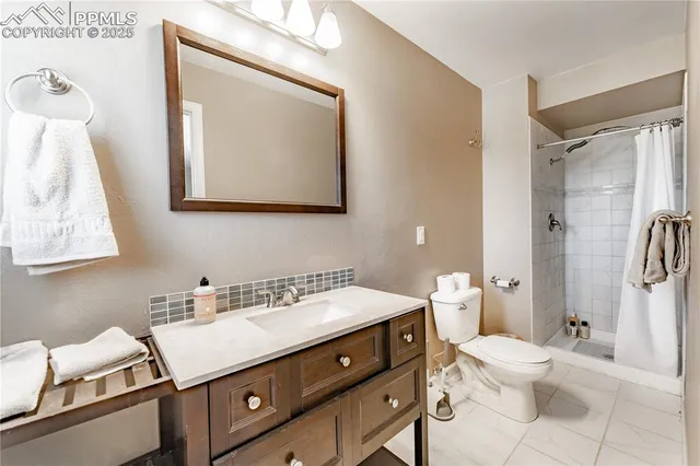 a bathroom with a sink vanity granite and toilet