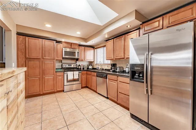 a kitchen with stainless steel appliances granite countertop a refrigerator and a stove top oven