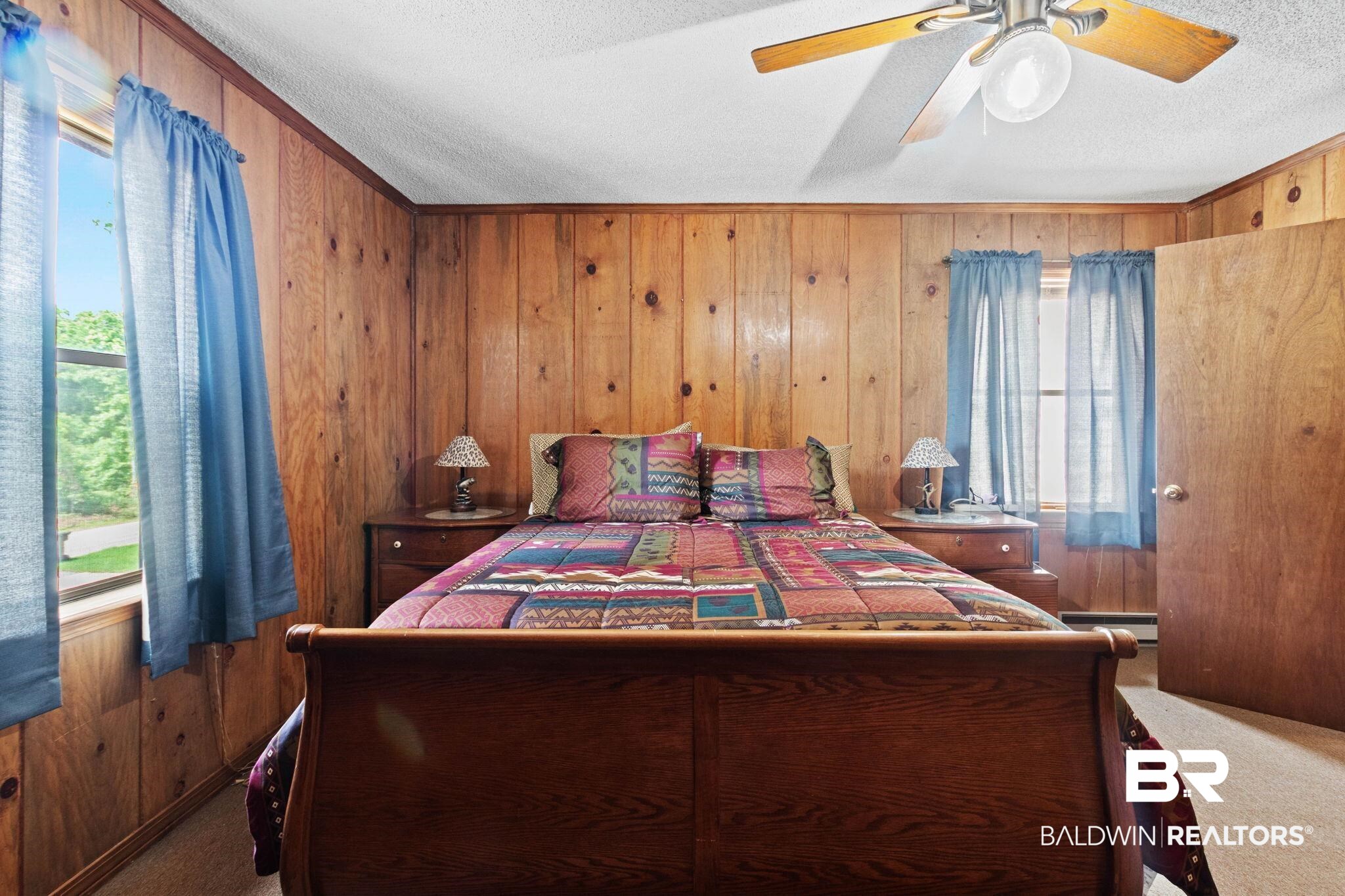 8153 Bryant's Lndg Road Stockton, AL 36579 - Photo 36 of 87 Interior room featuring wood paneling throughout, a ceiling fan with light fixture, and two windows