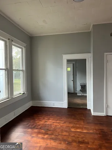 a view of a room with wooden floor and a window