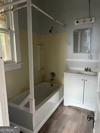 a bathroom with a tub a sink and a mirror