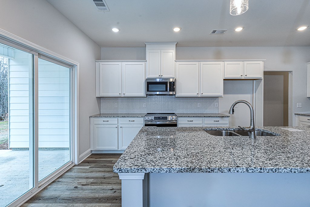 8711 McKee Road Upatoi, GA 31829 - Photo 12 of 45 a kitchen with stainless steel appliances granite countertop a sink stove and cabinets