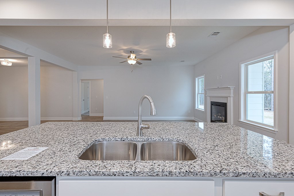 8711 McKee Road Upatoi, GA 31829 - Photo 17 of 45 a kitchen with kitchen island granite countertop a sink a counter top space and cabinets