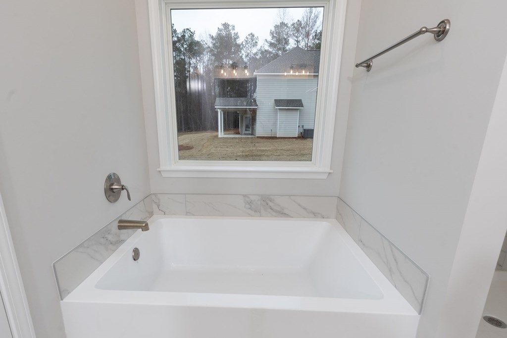 8711 McKee Road Upatoi, GA 31829 - Photo 32 of 45 a white bath tub sitting in a bathroom next to a window