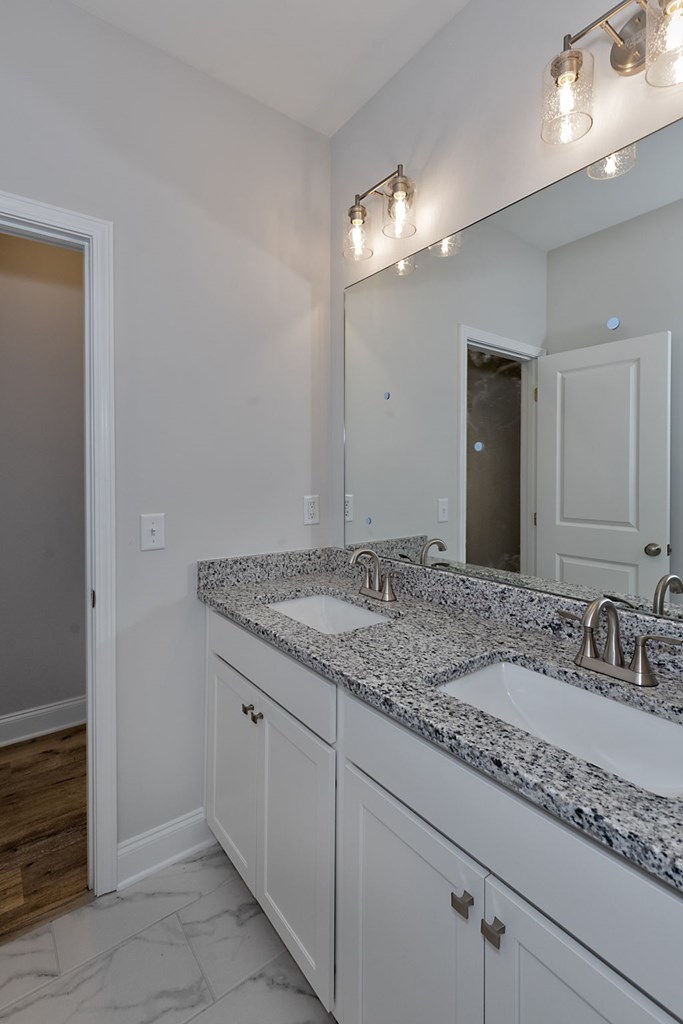 8711 McKee Road Upatoi, GA 31829 - Photo 41 of 45 a bathroom with a granite countertop sink and a mirror