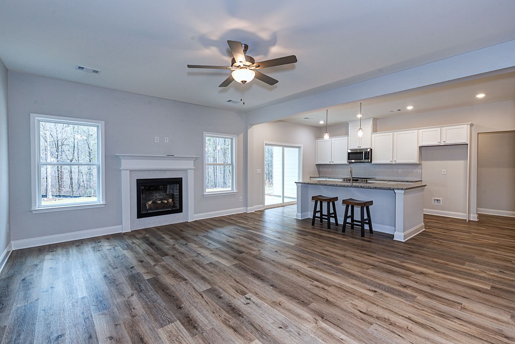 8711 McKee Road Upatoi, GA 31829 - Photo 7 of 45 a view of a kitchen and dining room with wooden floor a fireplace