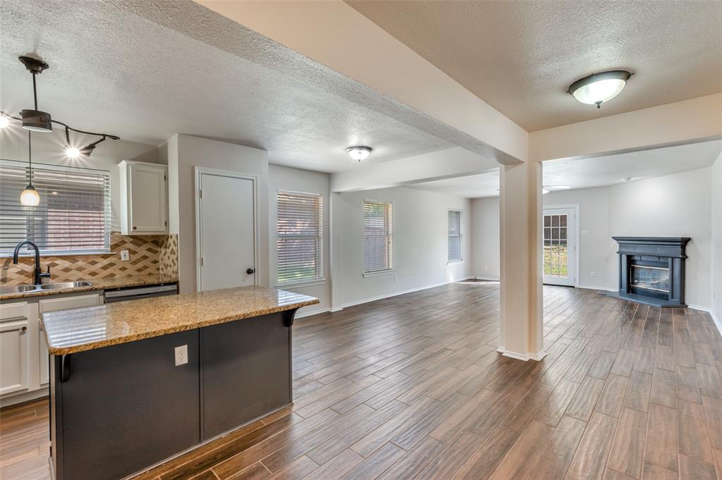 2606 Whetstone Drive Corinth, TX 76210 - Photo 9 of 28 a kitchen with granite countertop a stove and wooden floor