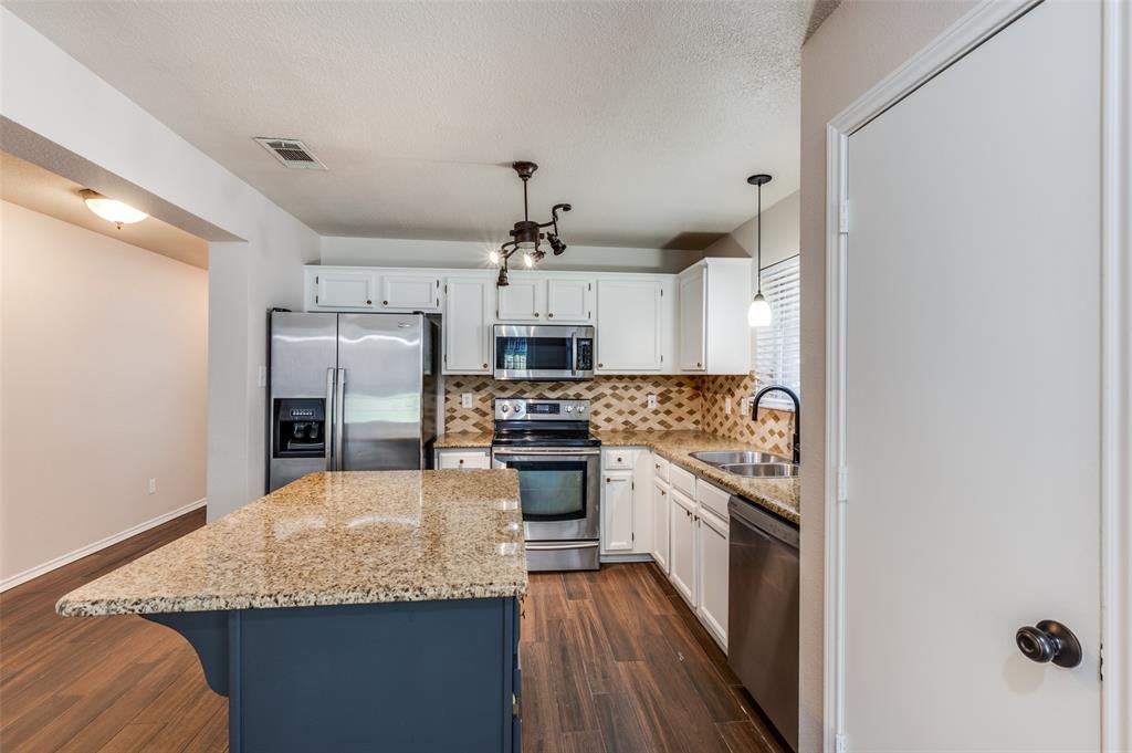 2606 Whetstone Drive Corinth, TX 76210 - Photo 10 of 28 a kitchen with stainless steel appliances granite countertop a sink stove and refrigerator