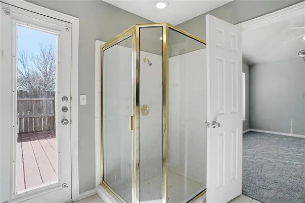 a bathroom with a glass shower door and a glass door
