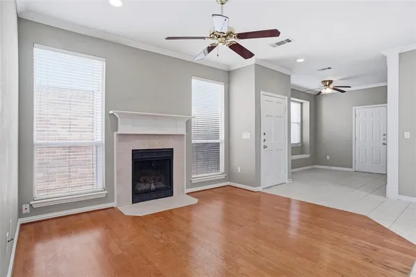 a view of an empty room with chandelier fan and fire place