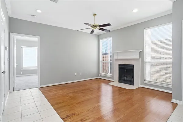 an empty room with windows fireplace and a sink
