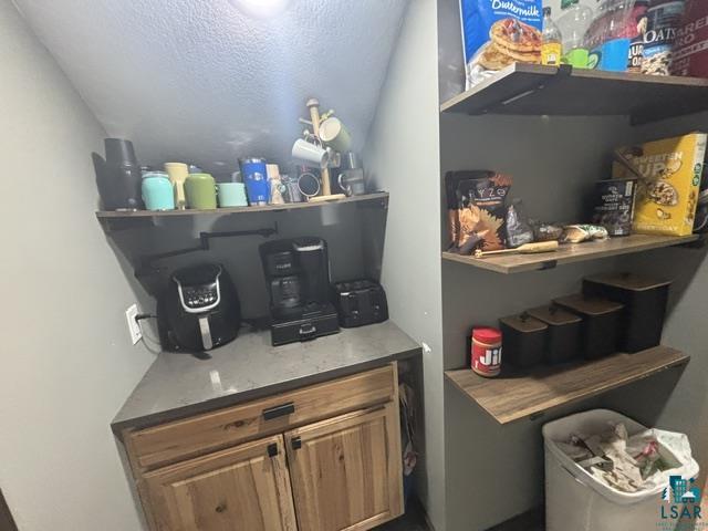 3454 Anderson Road Hibbing, MN 55746 - Photo 24 of 31 Built-in cabinetry with wood-finish doors, a solid surface countertop, and open shelving