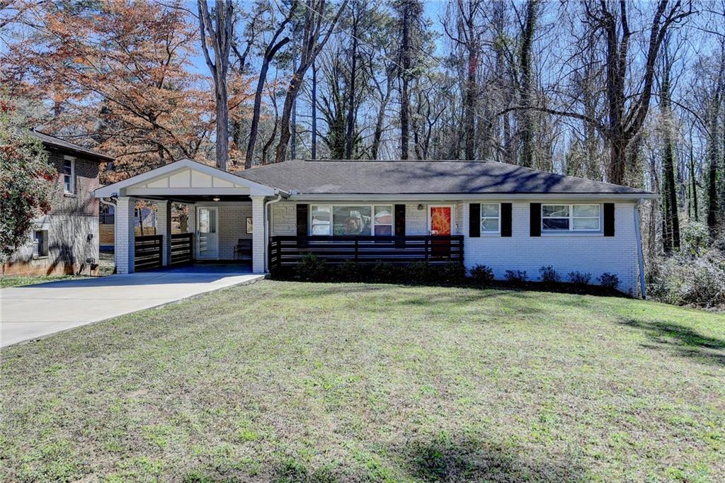 a front view of a house with a garden and trees