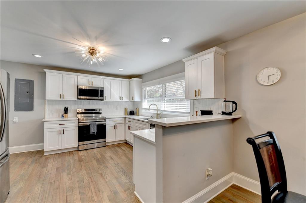 2945 Monterey Drive Decatur, GA 30032 - Photo 23 of 93 a kitchen with stainless steel appliances granite countertop a stove top oven a sink dishwasher a dining table and chairs with wooden floors