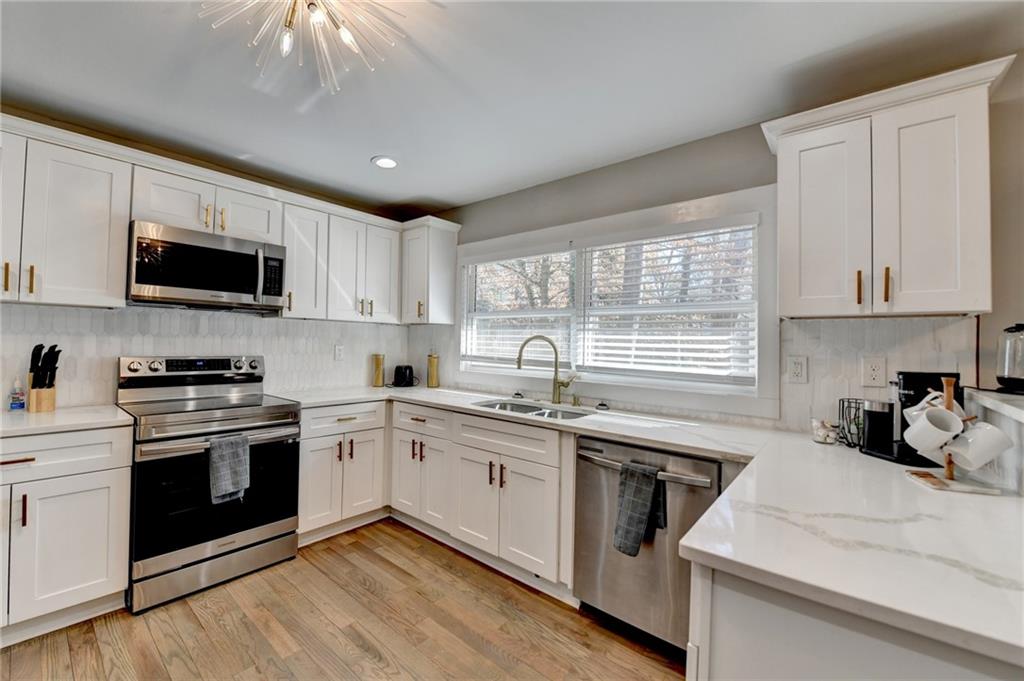 2945 Monterey Drive Decatur, GA 30032 - Photo 25 of 93 a kitchen with white cabinets stainless steel appliances a sink and a window