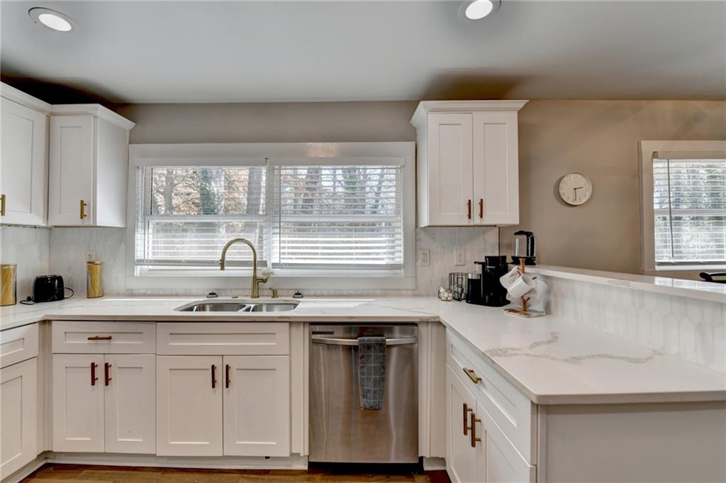 2945 Monterey Drive Decatur, GA 30032 - Photo 26 of 93 a kitchen with granite countertop a sink white cabinets and a window