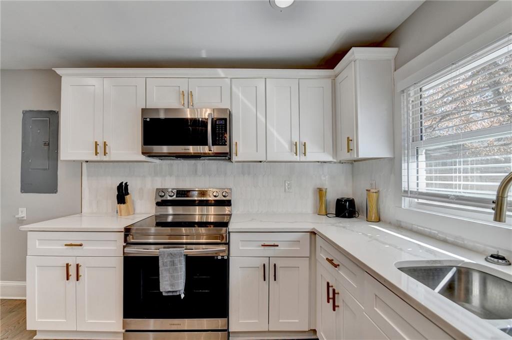 2945 Monterey Drive Decatur, GA 30032 - Photo 29 of 93 a kitchen with white cabinets and stainless steel appliances