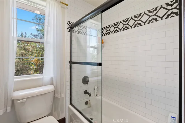 a bathroom with a sink a toilet and a large mirror