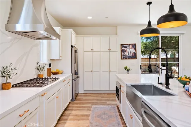 a kitchen with stainless steel appliances kitchen island granite countertop a sink a counter space and a window