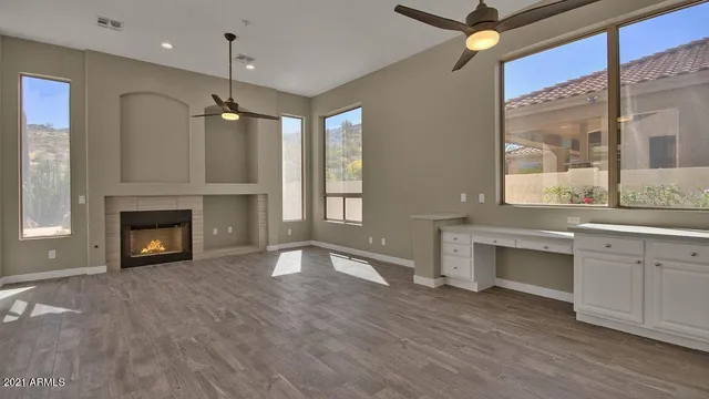 a view of an empty room with a fireplace and a window